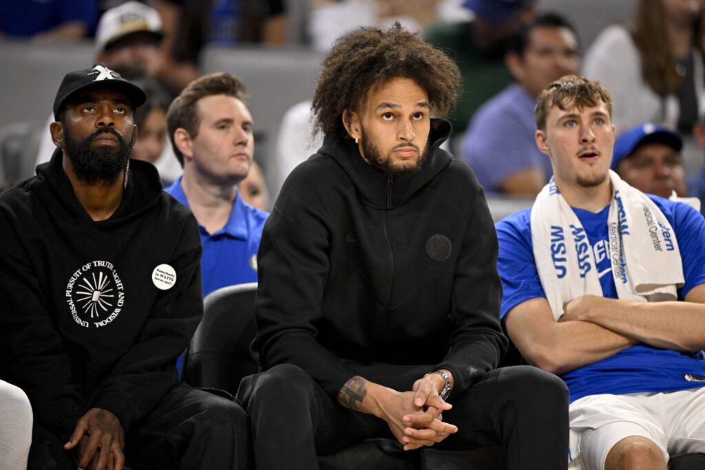 Dallas Mavericks guard Kyrie Irving (left) and center Dereck Lively II (center) and forward Cooper Flagg (right).