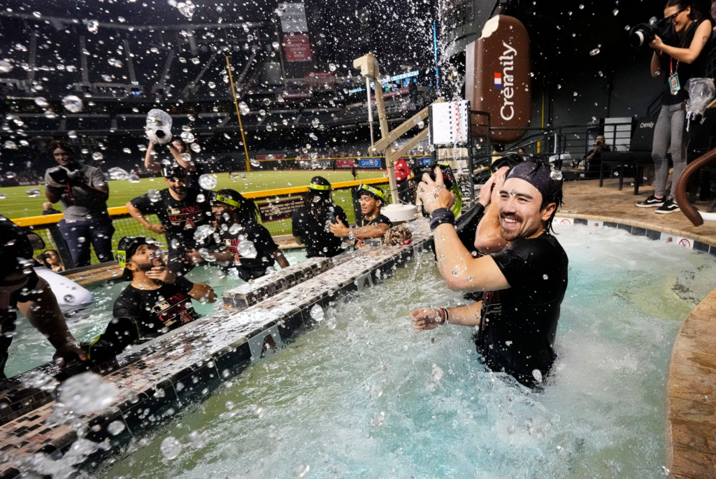 Diamondbacks outfielder Corbin Carroll splashes his teammates in the outfield pool during post-game celebrations after clinching a wild card playoff spot following their game with the Houston Astros at Chase Field on Sept 30, 2023.