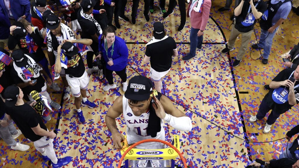 Former Sun Devils guard Remy Martin celebrates the Kansas Jayhawks NCAA Men's Basketball Championship by cutting down the net after defeating the North Carolina Tar Heels in 2022.