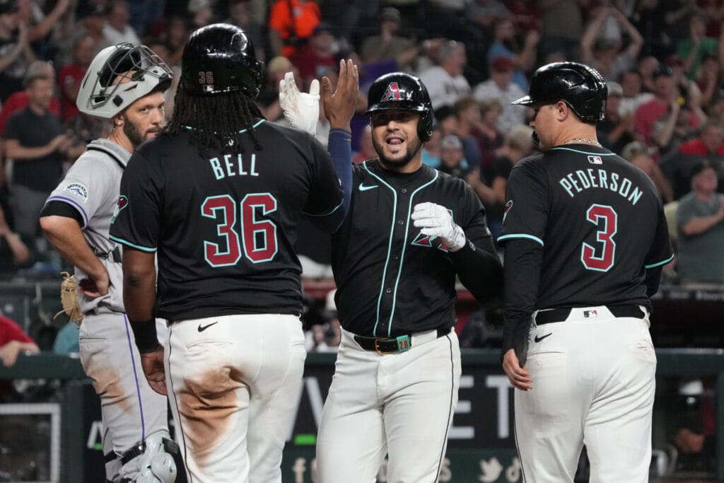 Diamondbacks third base Eugenio Suarez (28) celebrates with first baseman Josh Bell (36) and designated hitter Joc Pederson (3) after hitting a grand slam against the Colorado Rockies in the sixth inning at Chase Field.