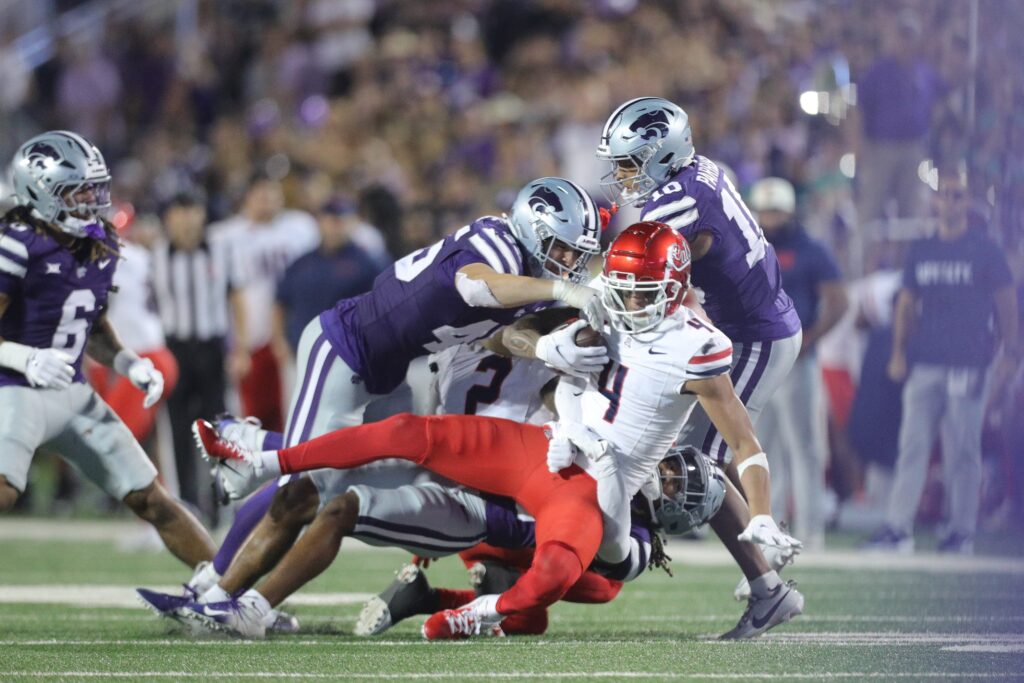 Arizona Wildcats wide receiver Tetairoa McMillan is taken down by Kansas State players. (The Topeka Capital-Journal)