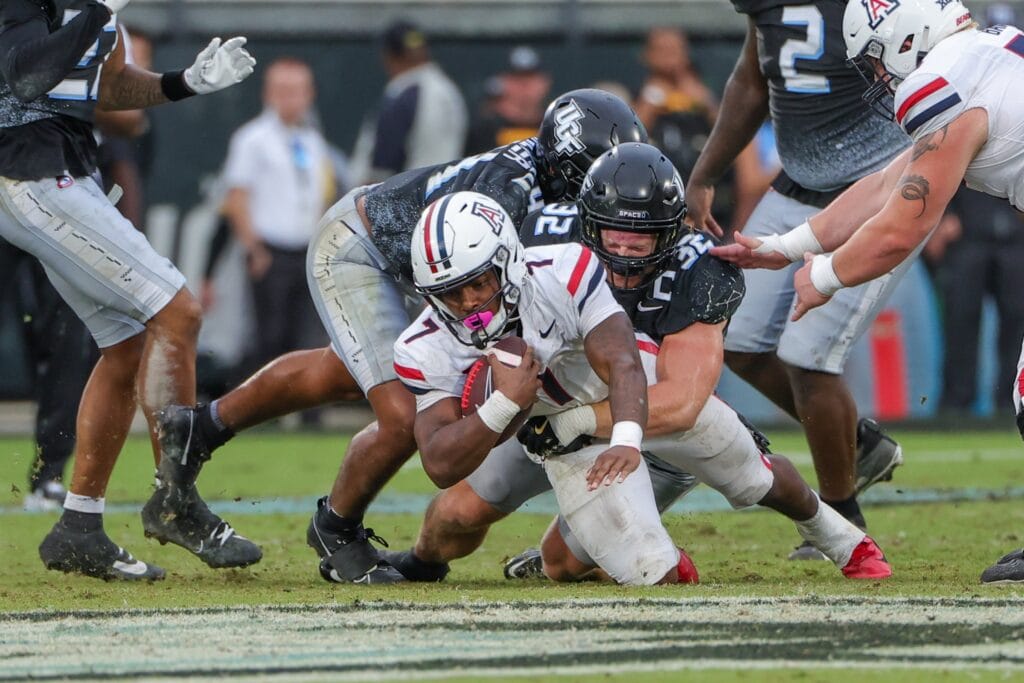 Arizona Wildcats running back Quali Conley is tackled by UCF Knights linebacker Ethan Barr. (Mike Watters-Imagn Images)