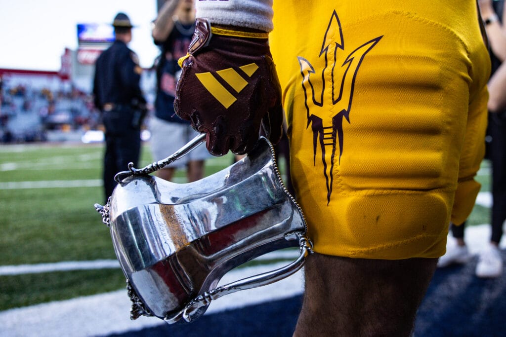 View of an Arizona State Sun Devils player holding the territorial cup.