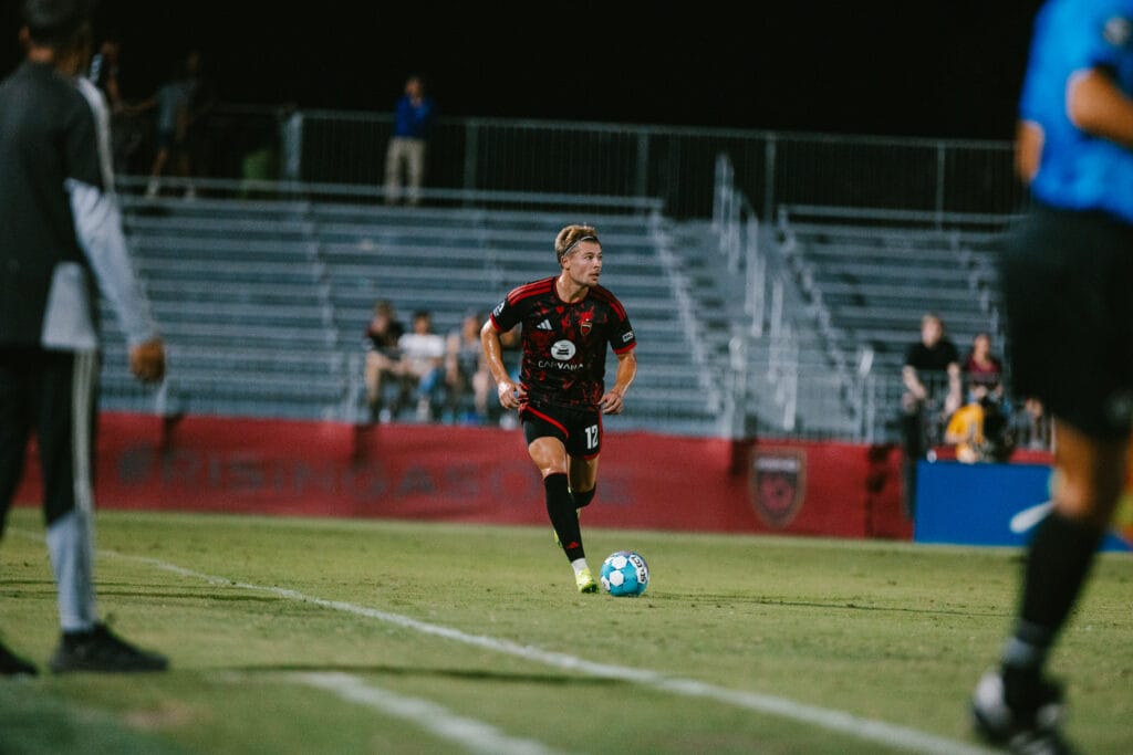 Charlie Dennis of Phoenix Rising runs with the ball at his feet.