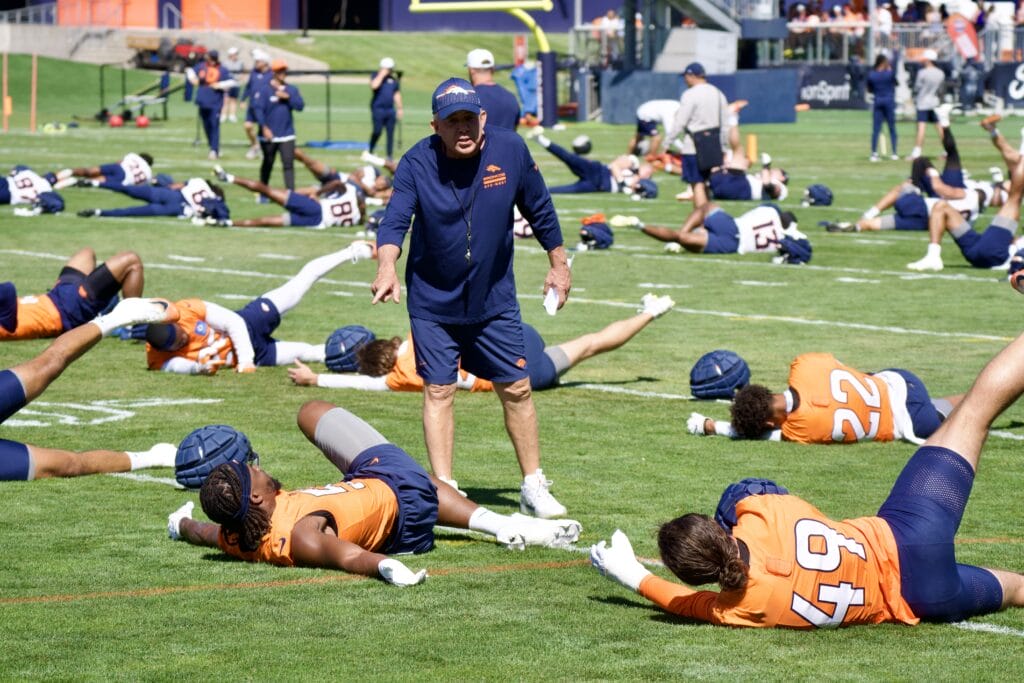 Sean Payton talking to players as the Denver Broncos warm up for training camp