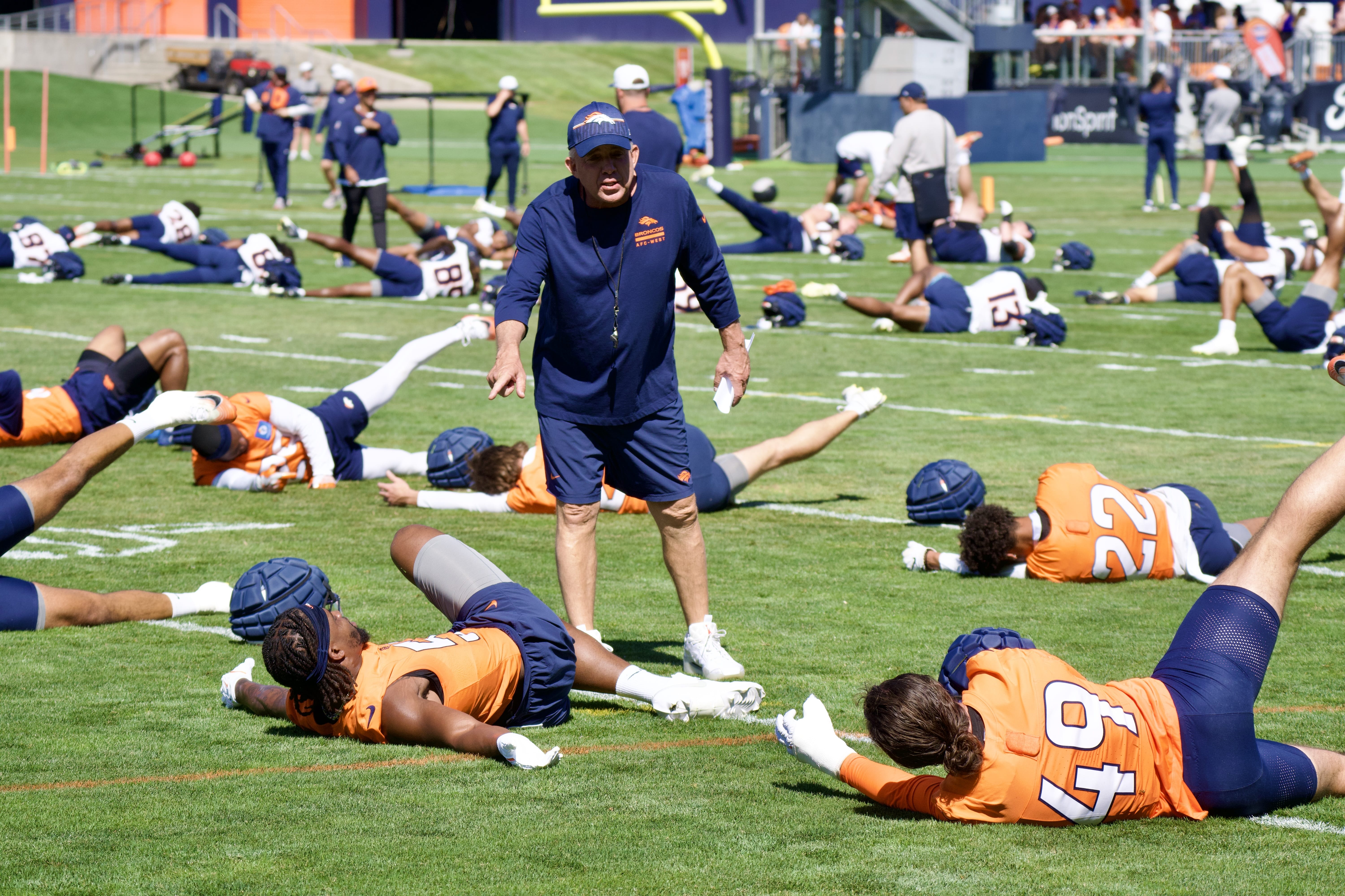 Sean Payton talking to players as the Denver Broncos warm up for training camp