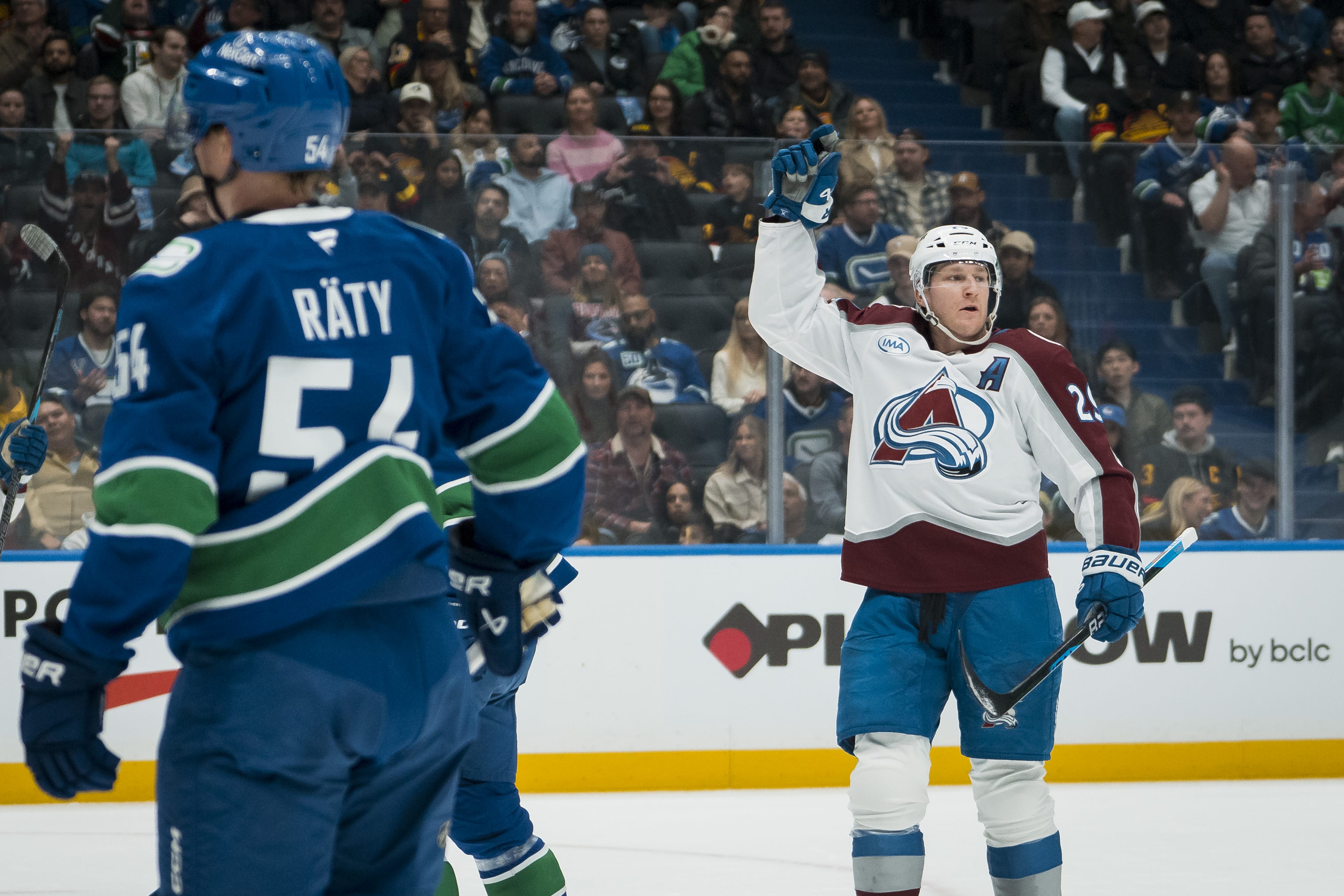 Vancouver Canucks forward Aatu Raty (54) and forward Kiefer Sherwood (44) react as Colorado Avalanche forward Nathan MacKinnon (29) celebrates his second goal of the game in the first period at Rogers Arena. Mandatory Credit: Bob Frid-Imagn Images