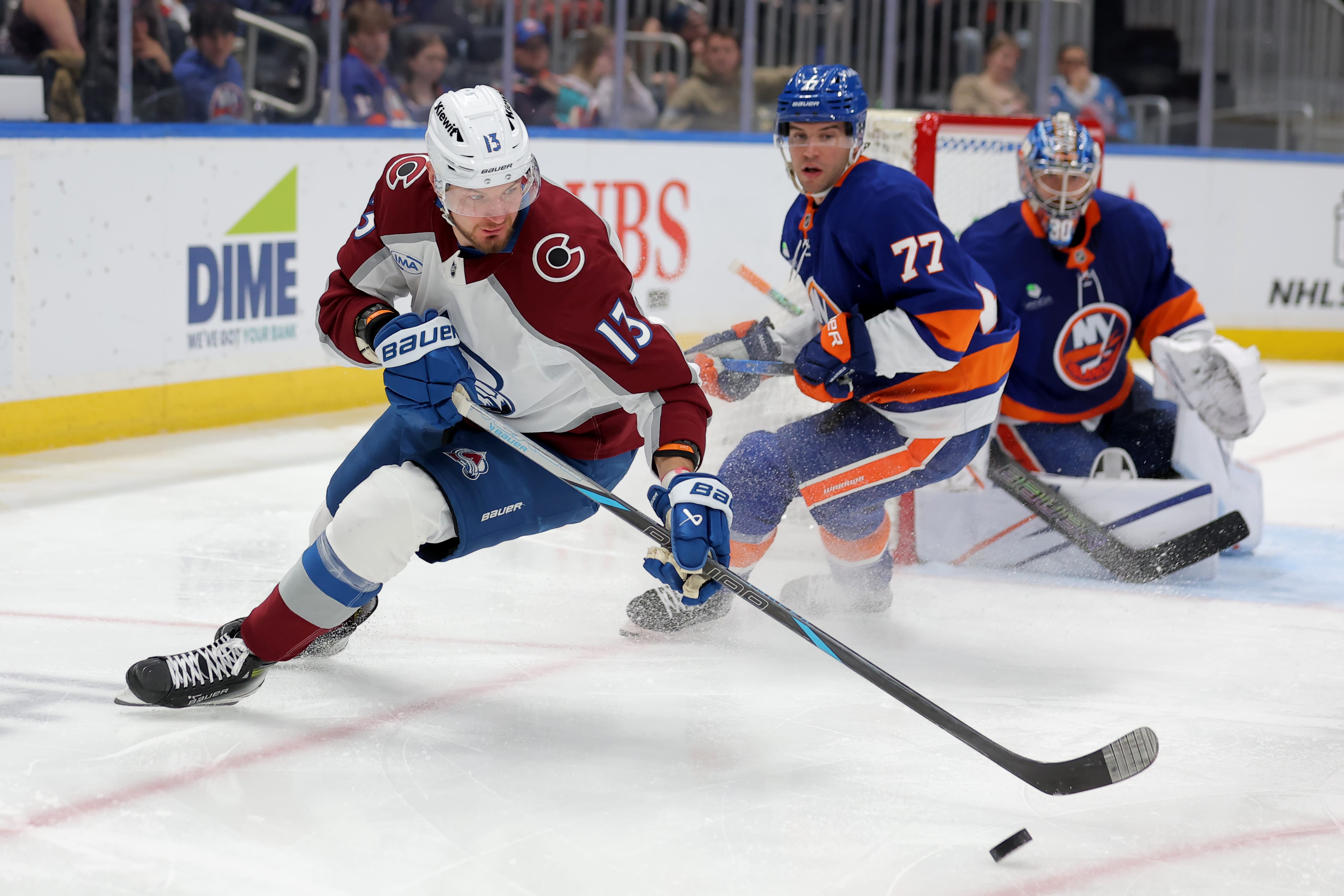 Colorado Avalanche right wing Valeri Nichushkin (13) plays the puck against New York Islanders defenseman Tony Deangelo (77) and goaltender Ilya Sorokin (30) during the third period at UBS Arena. Mandatory Credit: Brad Penner-Imagn Images