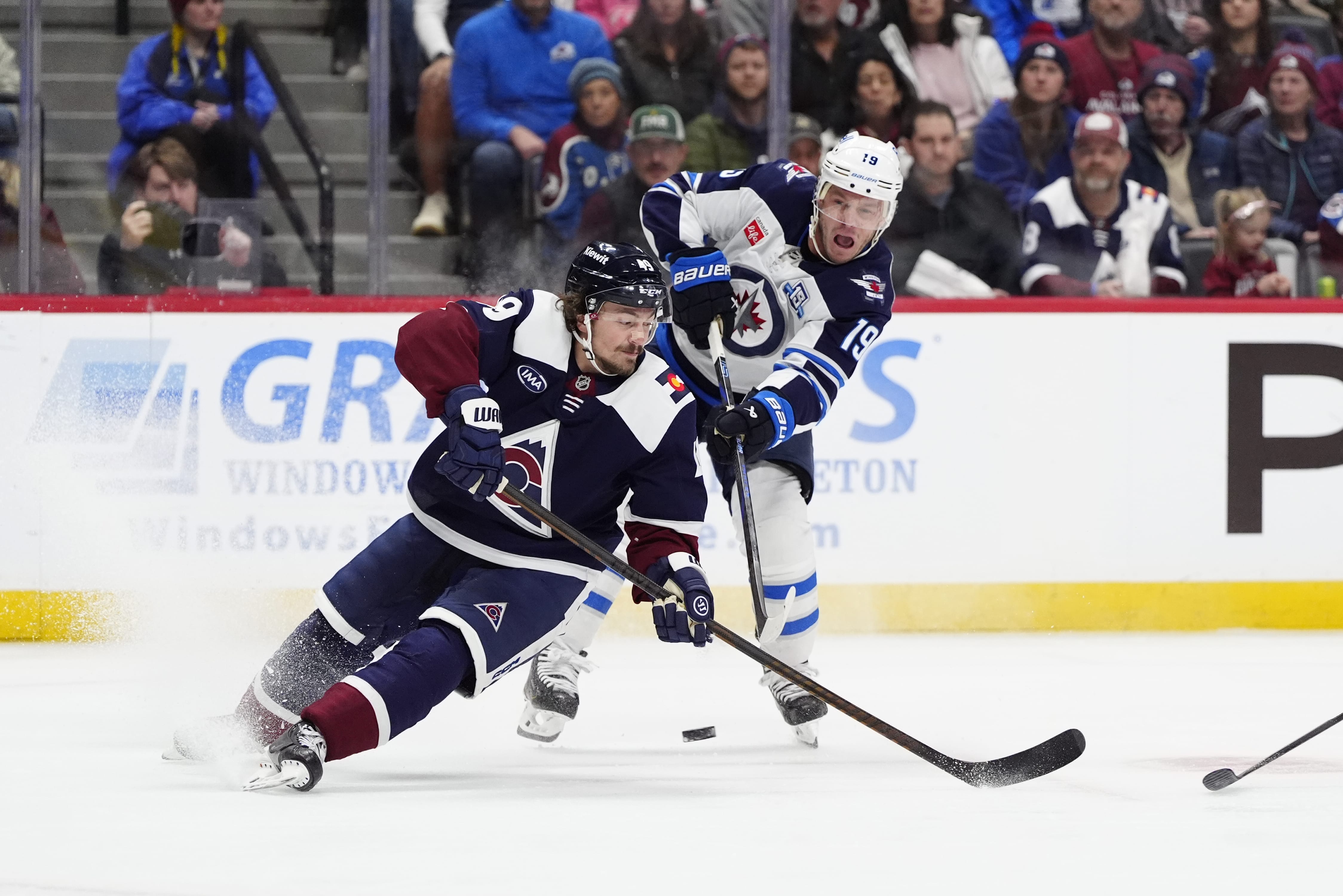 Winnipeg Jets center Jonathan Toews (19) shoot the puck past Colorado Avalanche defenseman Samuel Girard (49) in the first period at Ball Arena. Mandatory Credit: Ron Chenoy-Imagn Images