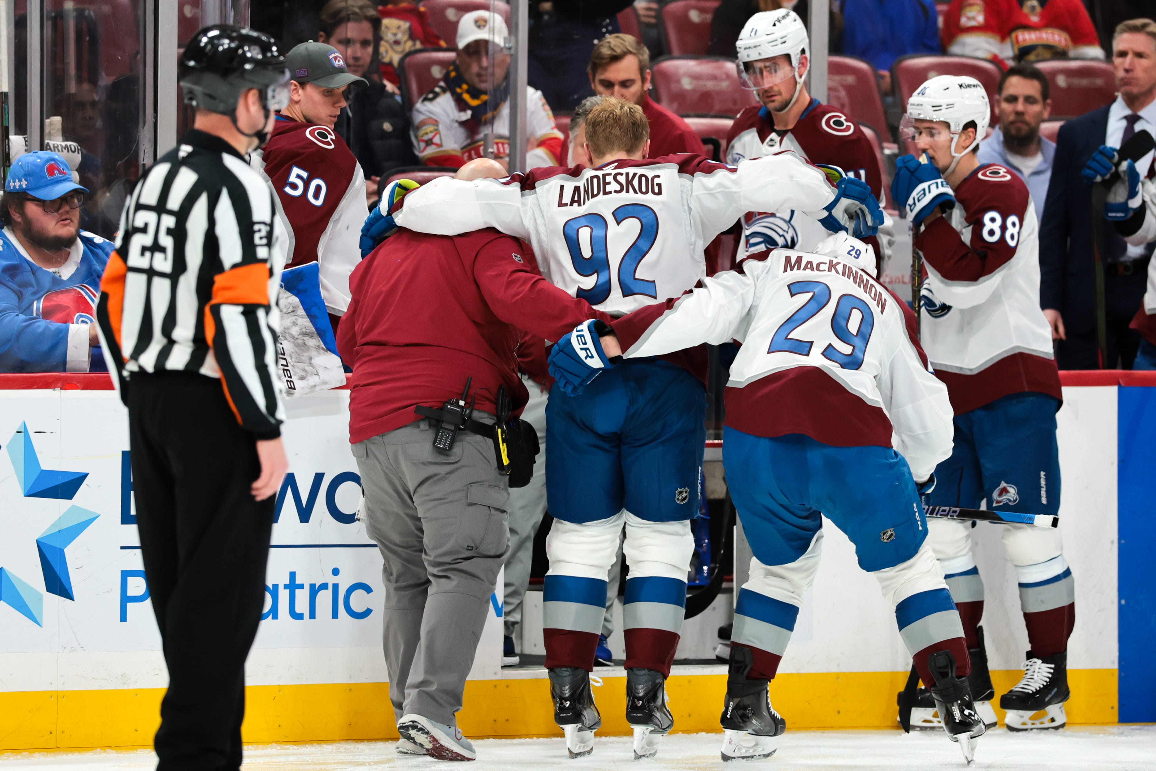 Colorado Avalanche left wing Gabriel Landeskog (92) is helped by center Nathan MacKinnon (29) to get off the ice after an injury against the Florida Panthers during the second period at Amerant Bank Arena. Mandatory Credit: Sam Navarro-Imagn Images