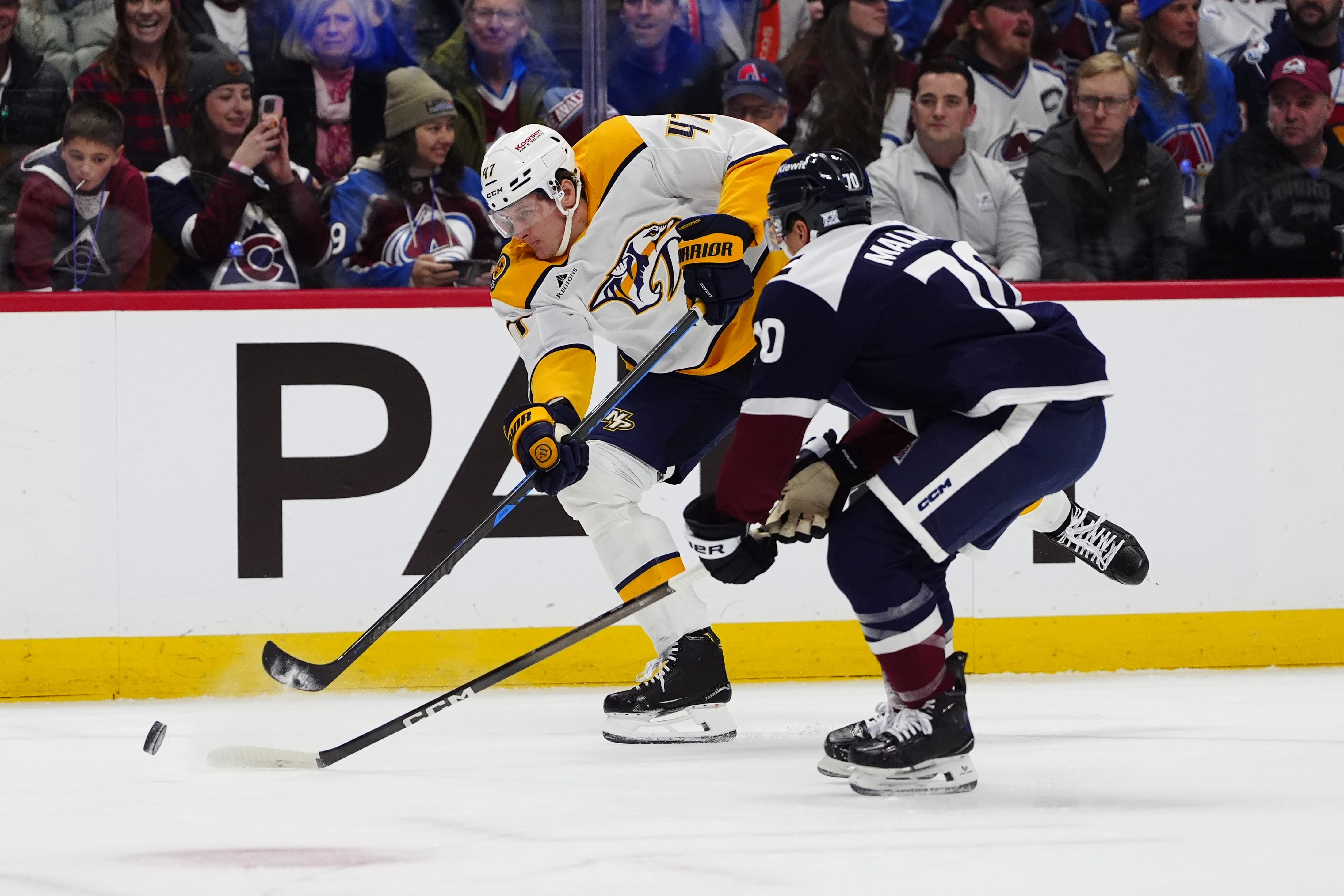 Colorado Avalanche defenseman Sam Malinski (70) defends the shot on goal by Nashville Predators right wing Michael McCarron (47) in the first period at Ball Arena. Mandatory Credit: Ron Chenoy-Imagn Images