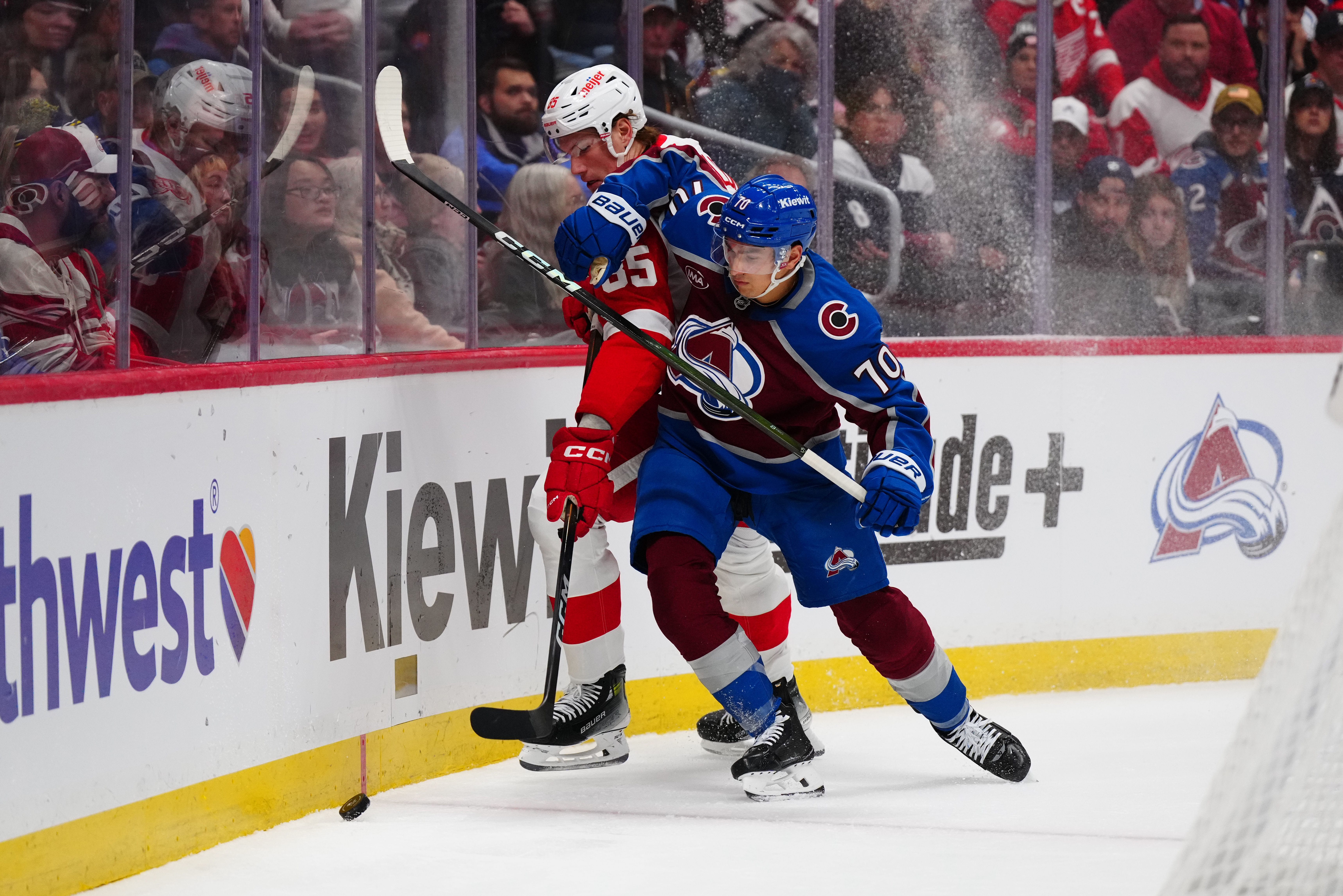 Colorado Avalanche defenseman Sam Malinski (70) and Detroit Red Wings left wing Elmer Soderblom (85) battle for the puck in the third period at Ball Arena. Mandatory Credit: Ron Chenoy-Imagn Images