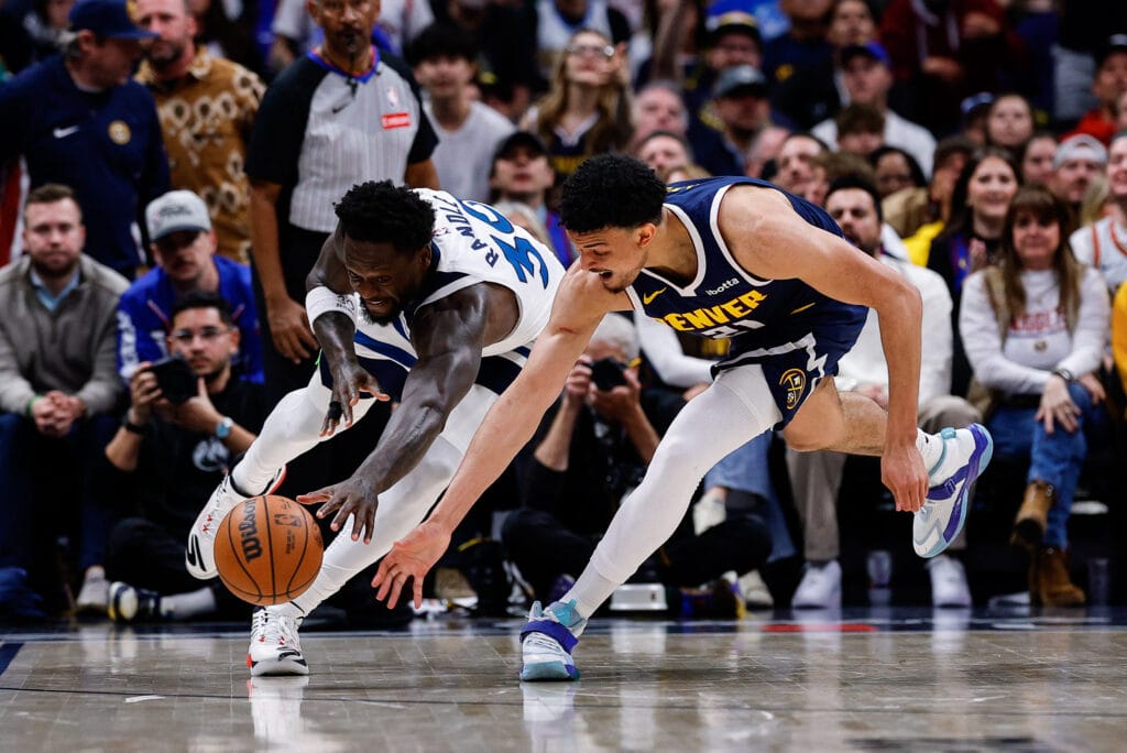 Spencer Jones of the Denver Nuggets fights with Julius Randle for a loose ball.
