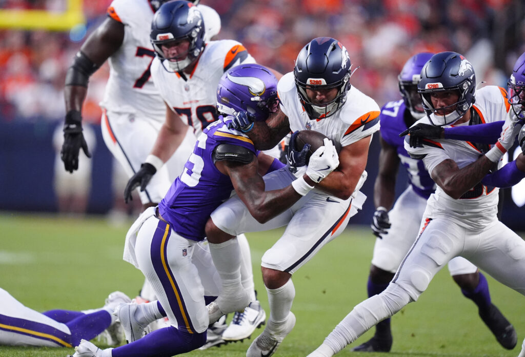 Aug 28, 2026; Denver, Colorado, USA; Minnesota Vikings safety Kahlef Hailassie (25) tackles Denver Broncos running back Cody Schrader (25) in the first quarter against the during a preseason game at Empower Field at Mile High. Mandatory Credit: Ron Chenoy-Imagn Images