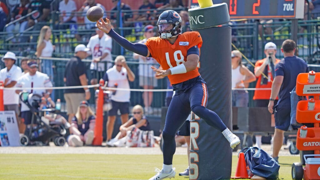 Bears QB Caleb Williams makes a leaping throw in training camp.