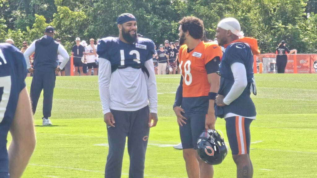 Keenan Allen, Caleb Williams, and DJ Moore huddle at Bears training camp.