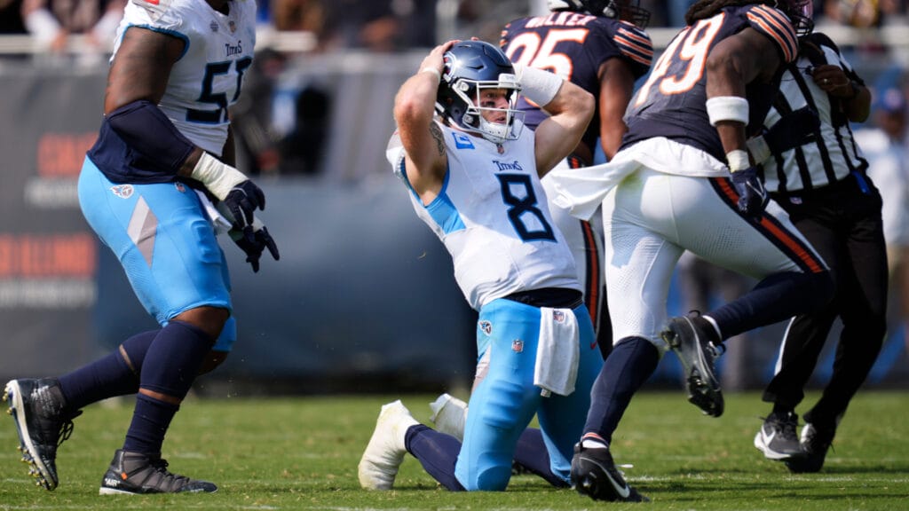 Will Levis kneels in disbelief after throwing an interception to Bears' Tyrique Stevenson.