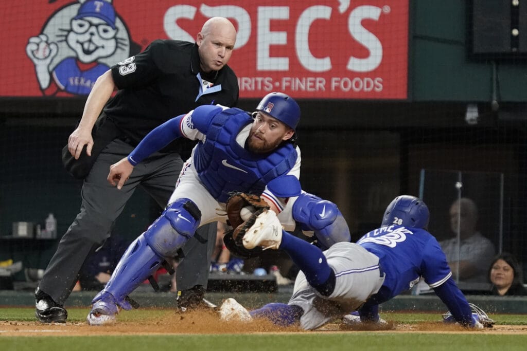 Toronto Blue Jays third baseman Ernie Clement (28) is tagged out trying to scoring by Texas Rangers catcher Carson Kelly (18) during the fourth inning at Globe Life Field.