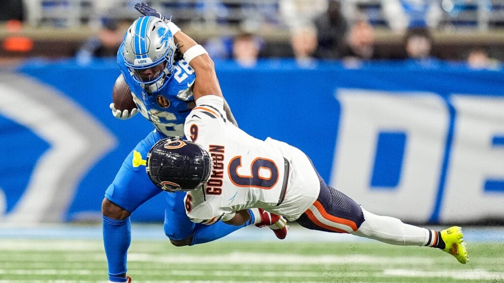 Detroit Lions running back Jahmyr Gibbs stiff-arms Bears corner Kyler Gordon