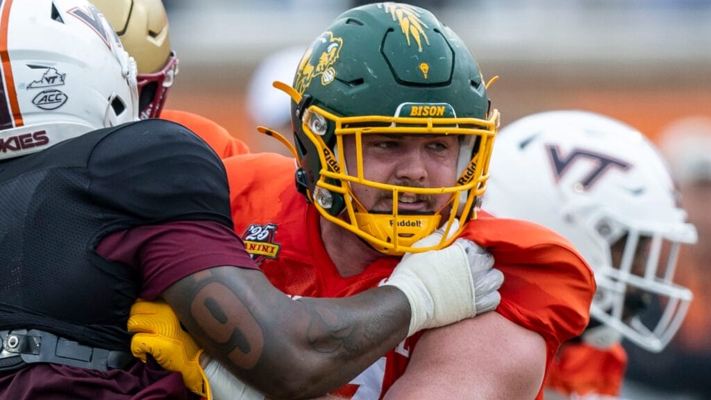 National team defensive lineman Aeneas Peebles of Virginia Tech (16) battles National team offensive lineman Grey Zabel of North Dakota State (77) during Senior Bowl practice for the National team at Hancock Whitney Stadium.