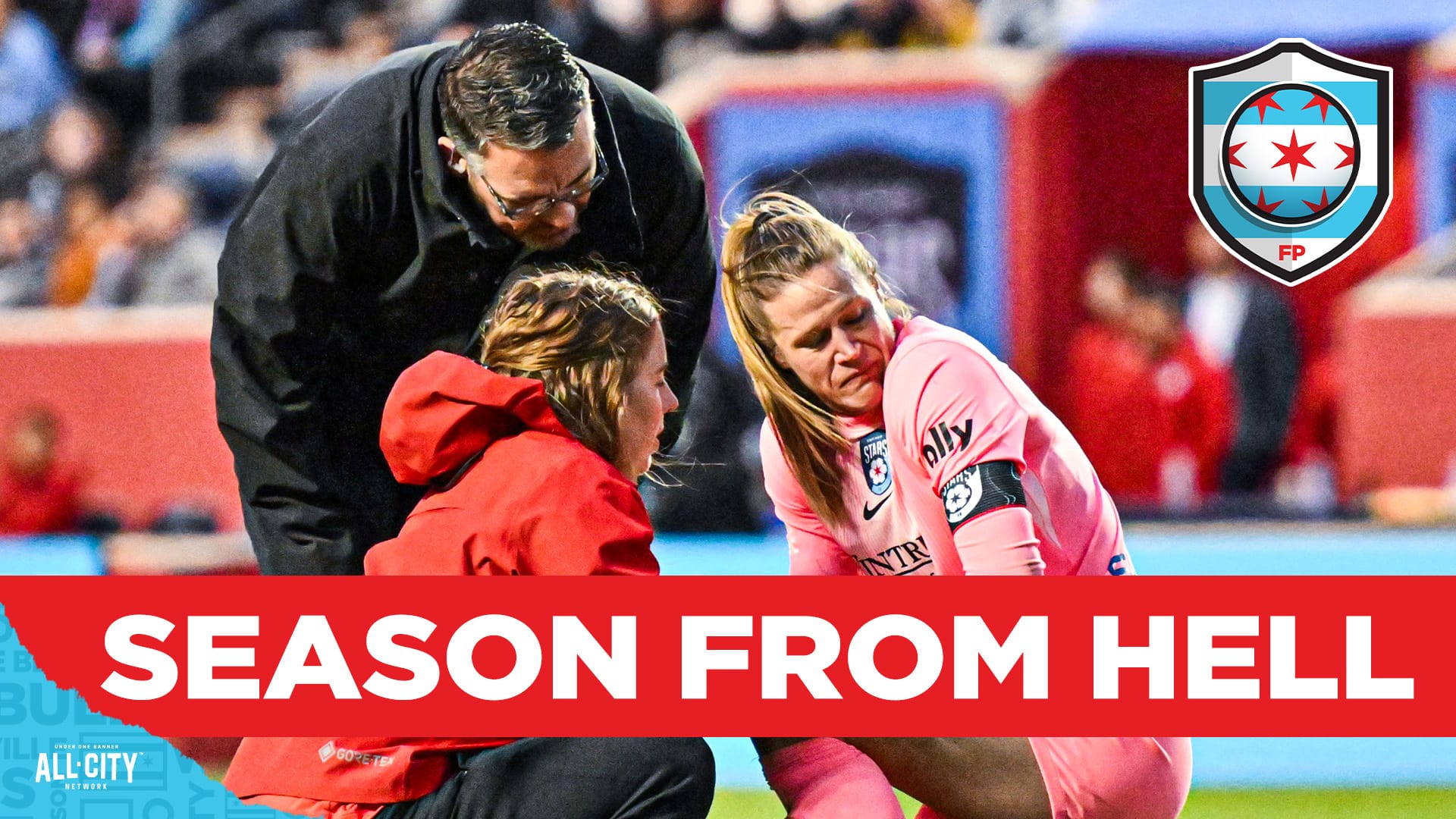 Chicago Stars goalkeeper Alyssa Naeher is tended to by training staff. Naeher is on one knee wearing an all pink goalkeeper kit. A woman crouching in front of her wears a red jacket, while a man in all black with dark hair and dark beard bends down to listen. A red banner across the lower third of the picture with white text reads 'Season From Hell' and the CHGO Stars logo is in the upper right corner.