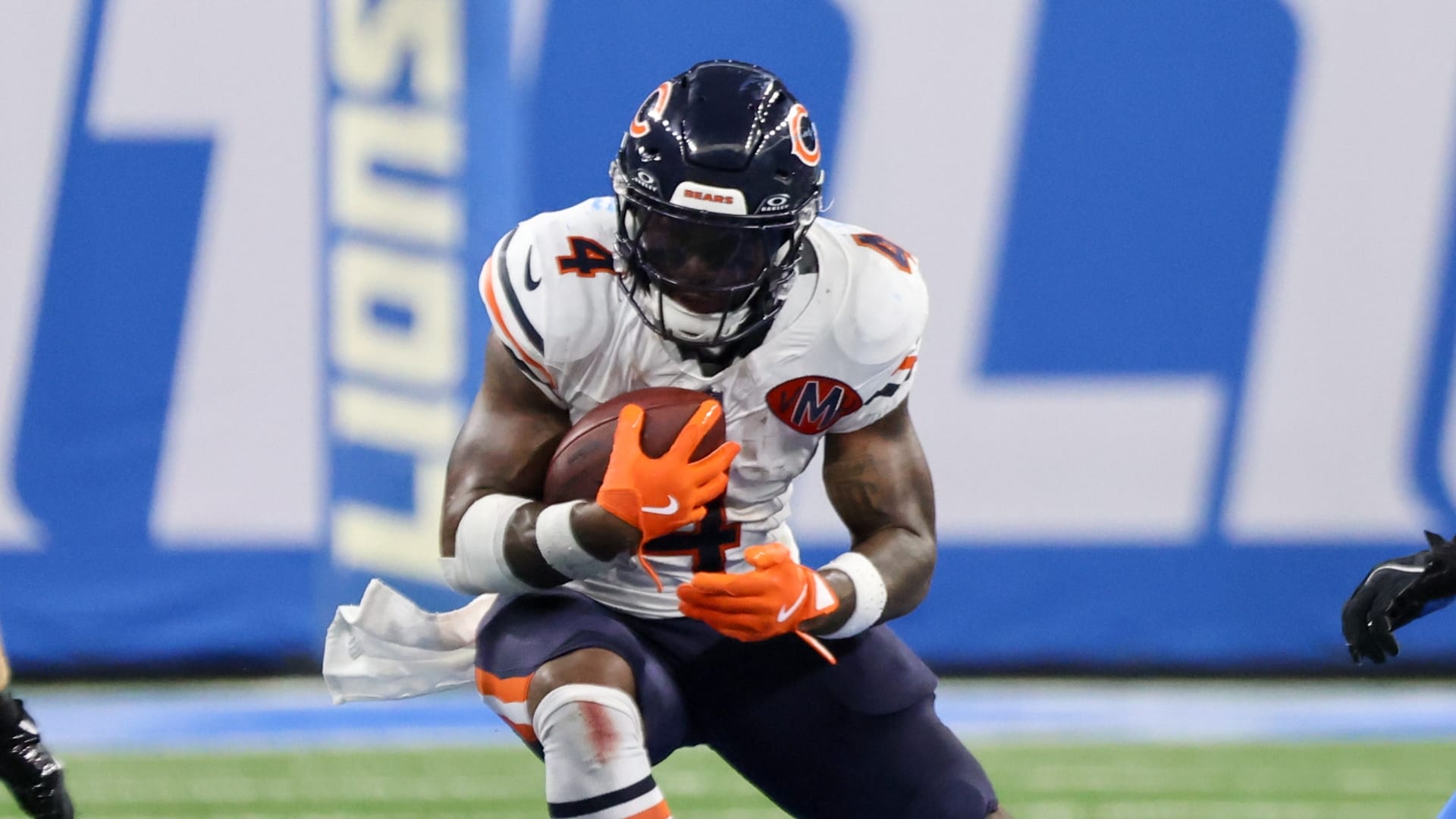 Chicago Bears running back D'Andre Swift (4) carries the ball defended by Detroit Lions linebacker Alex Anzalone (34) and safety Kerby Joseph (31) during the second quarter of the game at Ford Field.