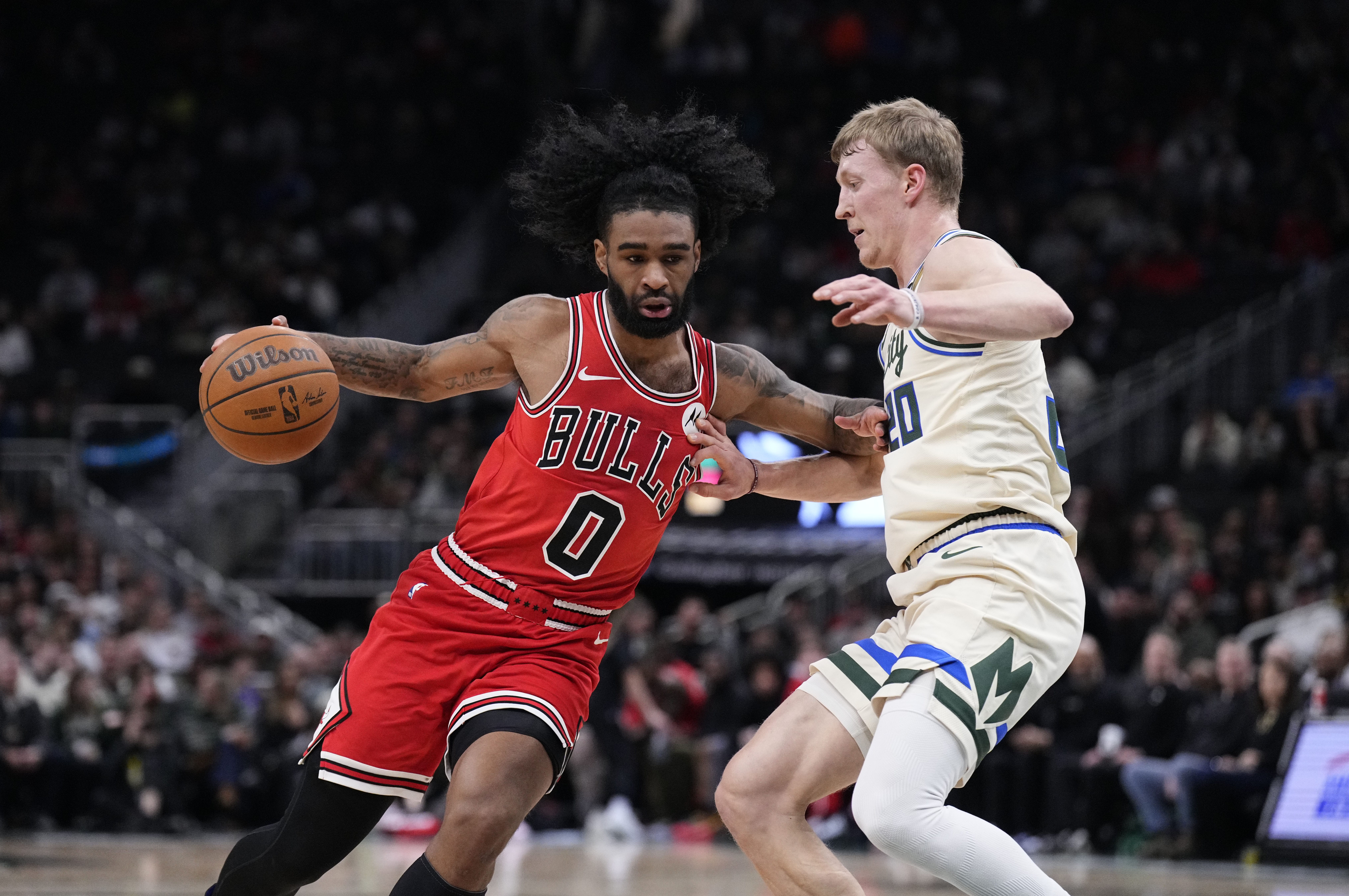 Feb 3, 2026; Milwaukee, Wisconsin, USA; Chicago Bulls guard Coby White (0) drives to the basket against Milwaukee Bucks guard AJ Green (20) in the first half at Fiserv Forum.