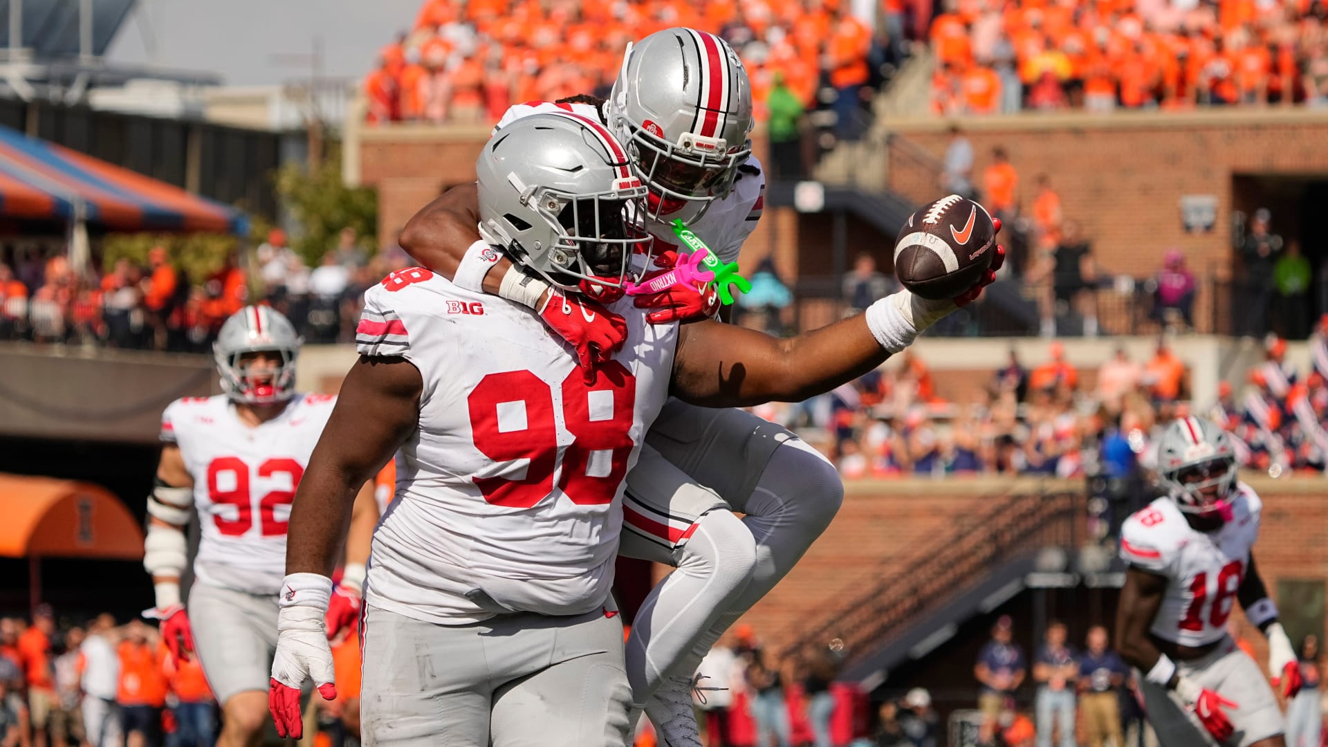 Potential Chicago Bears draft prospect and Ohio State Buckeyes defensive lineman Kayden McDonald (98) celebrates a fumble recovery with cornerback Jermaine Mathews Jr. (7) after stripping the ball from Illinois Fighting Illini running back Ca'Lil Valentine (5) during the first half of the NCAA football game at Gies Memorial Stadium in Champaign on Oct. 11, 2025.