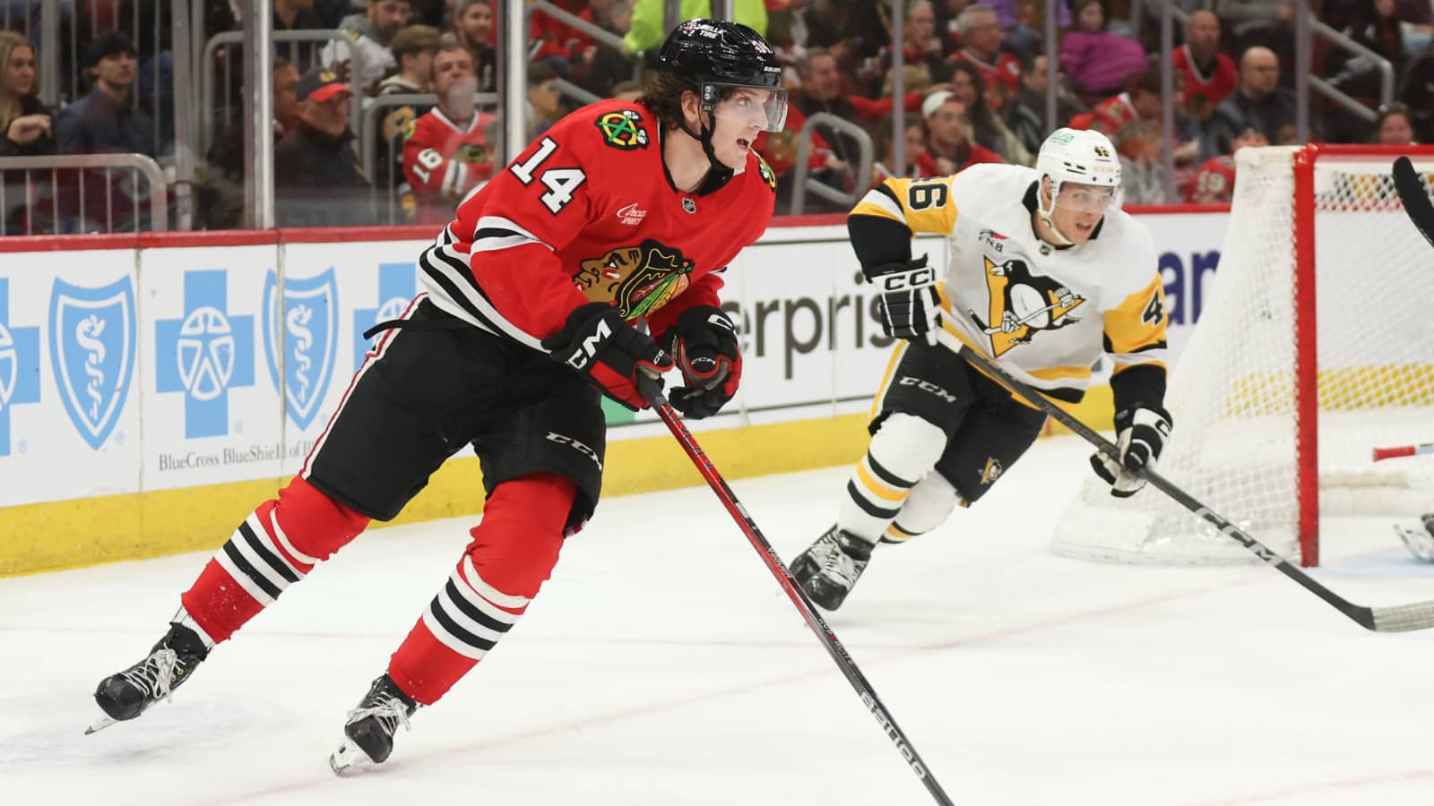Apr 6, 2025; Chicago, Illinois, USA; Chicago Blackhawks defenseman Kevin Korchinski (14) skates with the puck against the Pittsburgh Penguins during the second period at United Center.