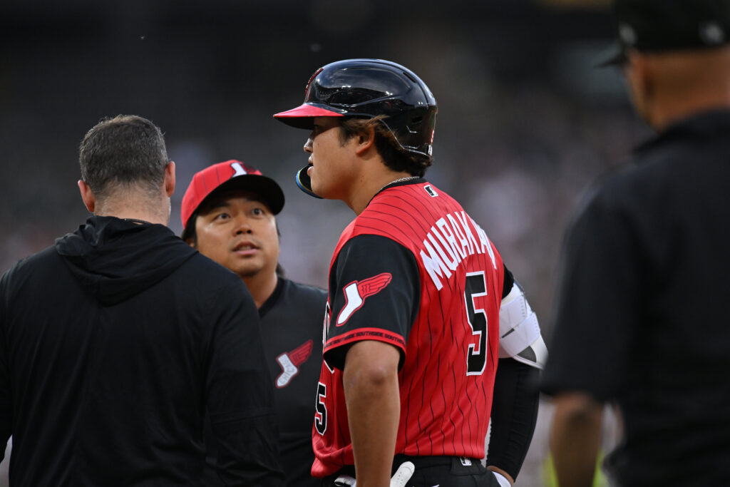 May 29, 2026; Chicago, Illinois, USA; Chicago White Sox first baseman Munetaka Murakami (5) looks on and chats with interpreter Kenzo Yagi (center) before being taken out of the game on a hamstring injury during the third inning against the Detroit Tigers at Rate Field.