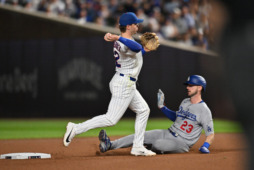 Aug 3, 2026; Chicago, Illinois, USA; Chicago Cubs second baseman Nico Hoerner (2) completes a double play after forcing out Los Angeles Dodgers right fielder Kyle Tucker (23) during the ninth inning at Wrigley Field.