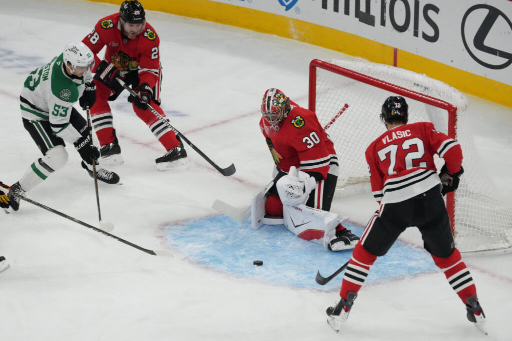 Oct 17, 2026; Chicago, Illinois, USA; Chicago Blackhawks goaltender Spencer Knight (30) stops the puck shot by Dallas Stars center Wyatt Johnston (53) during the first period at United Center. Mandatory Credit: David Banks-Imagn Images