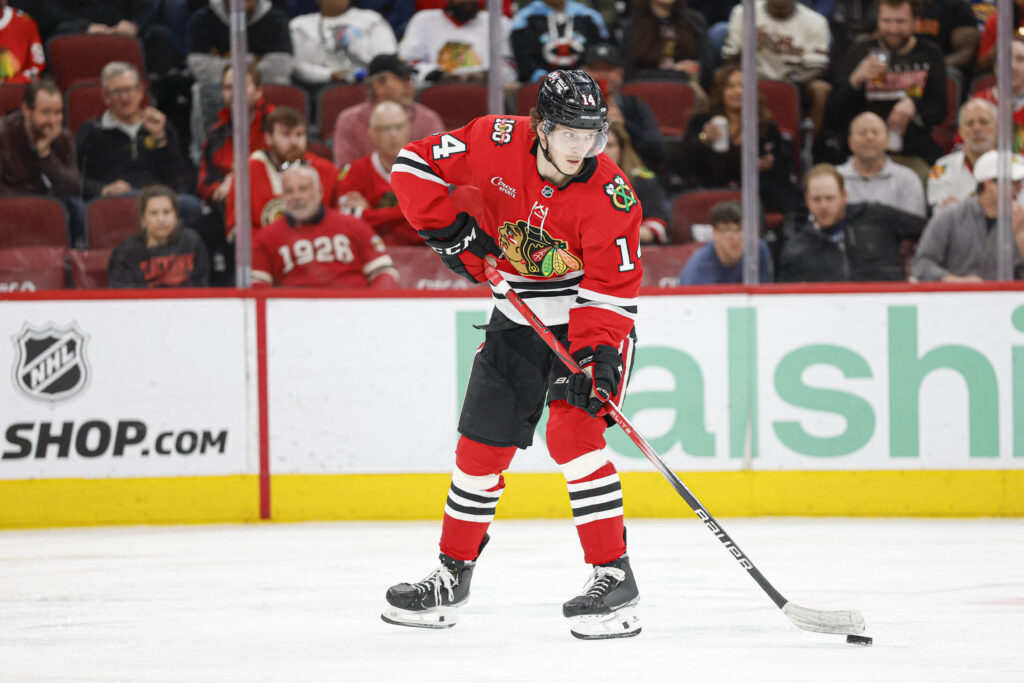 Apr 13, 2026; Chicago, Illinois, USA; Chicago Blackhawks defenseman Kevin Korchinski (14) looks to pass the puck against the Buffalo Sabres during the second period at United Center. Mandatory Credit: Kamil Krzaczynski-Imagn Images