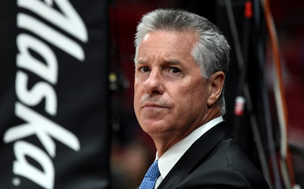 Neil Olshey standing courtside at a Nets vs. Blazers game.