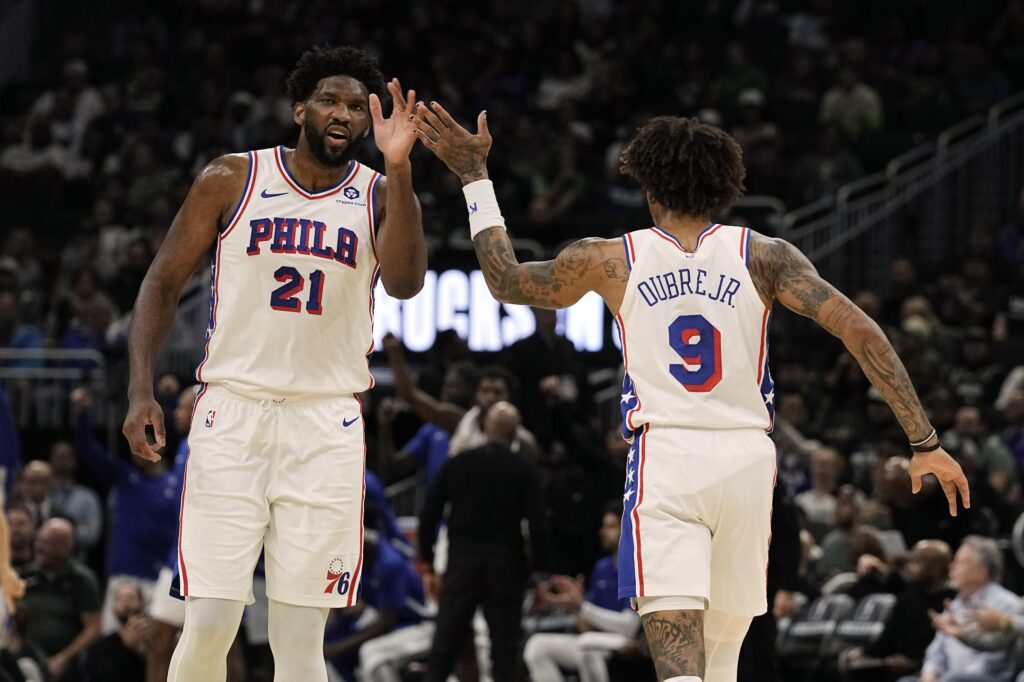 Joel Embiid and Kelly Oubre high fiving.