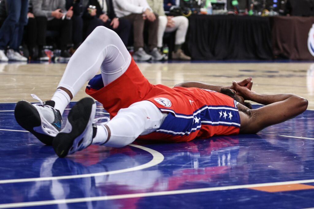 Joel Embiid laying on his back after a tough fall.