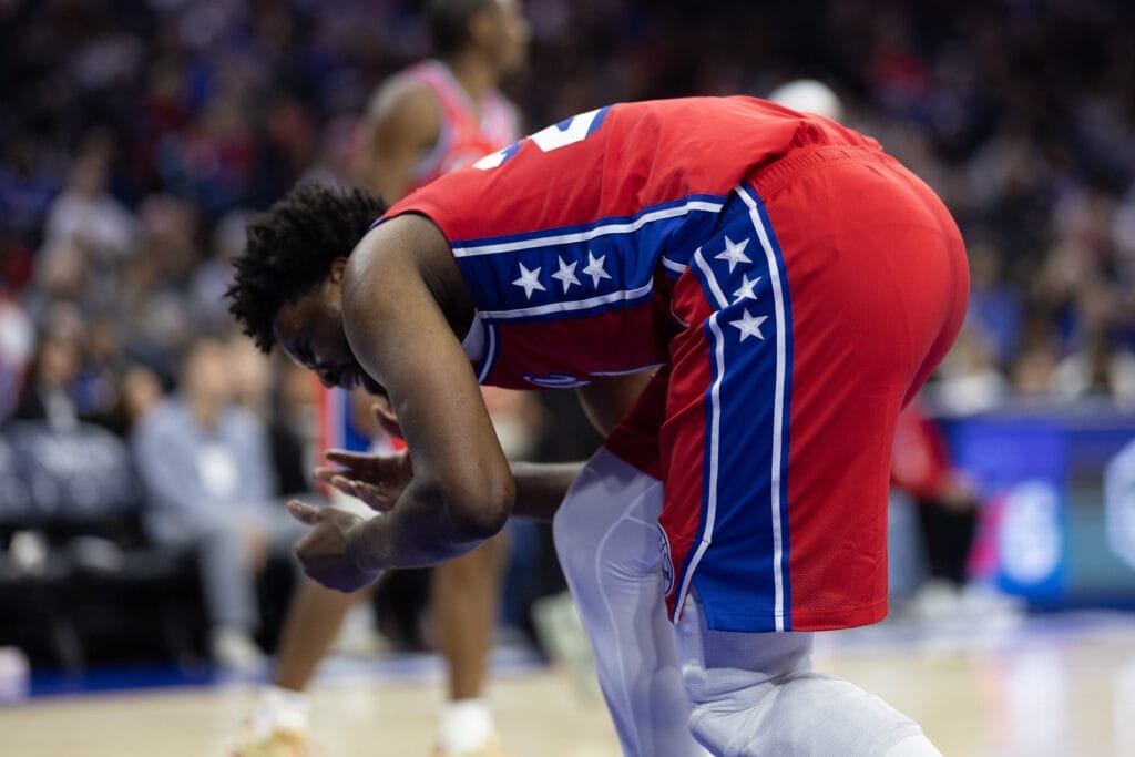 Joel Embiid hunched over with a face injury.