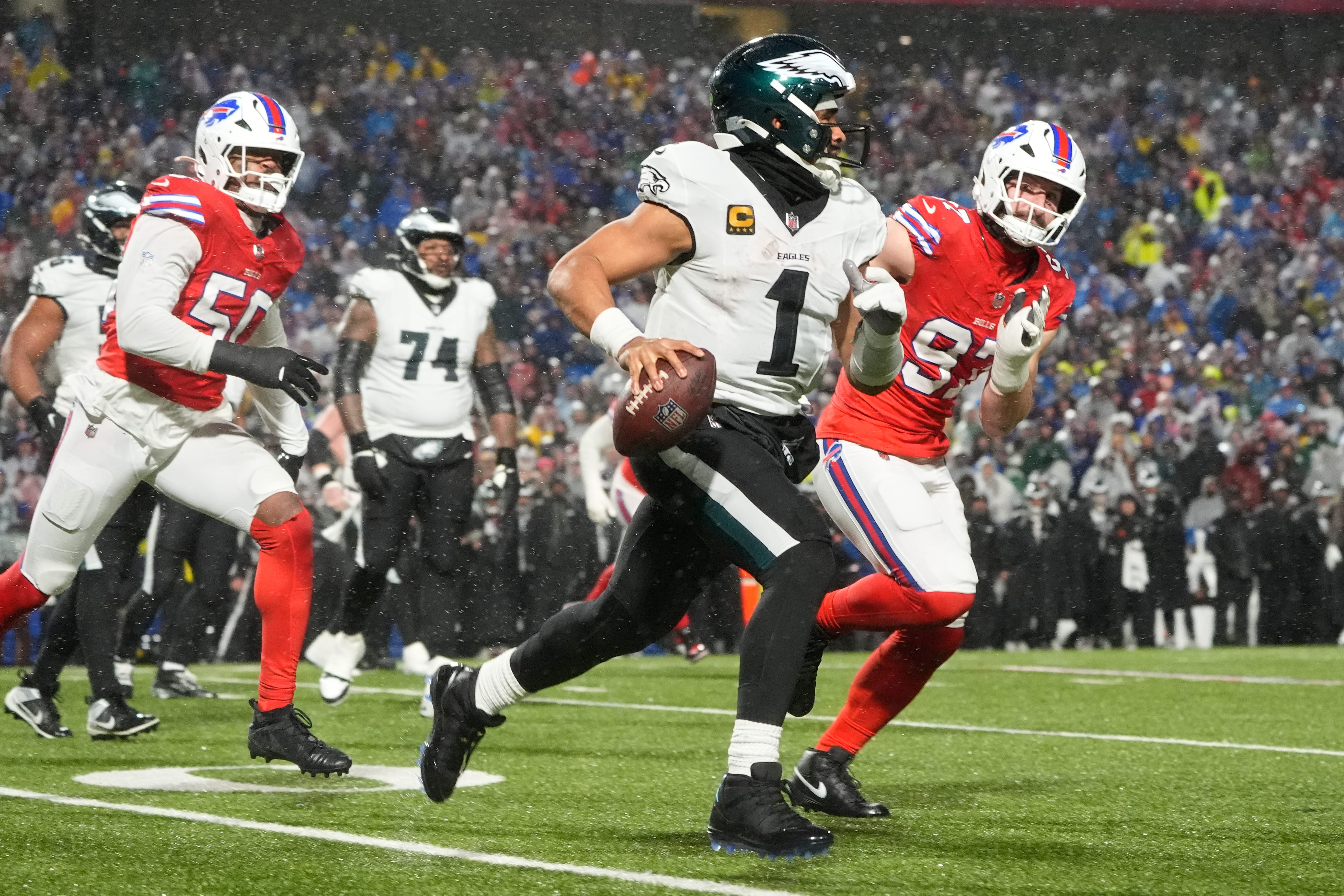 Eagles quarterback Jalen Hurts (1) scrambles against Buffalo Bills defensive ends Joey Bosa (97) and Greg Rousseau (50) during the third quarter at Highmark Stadium. Mandatory Credit: Gregory Fisher-Imagn Images
